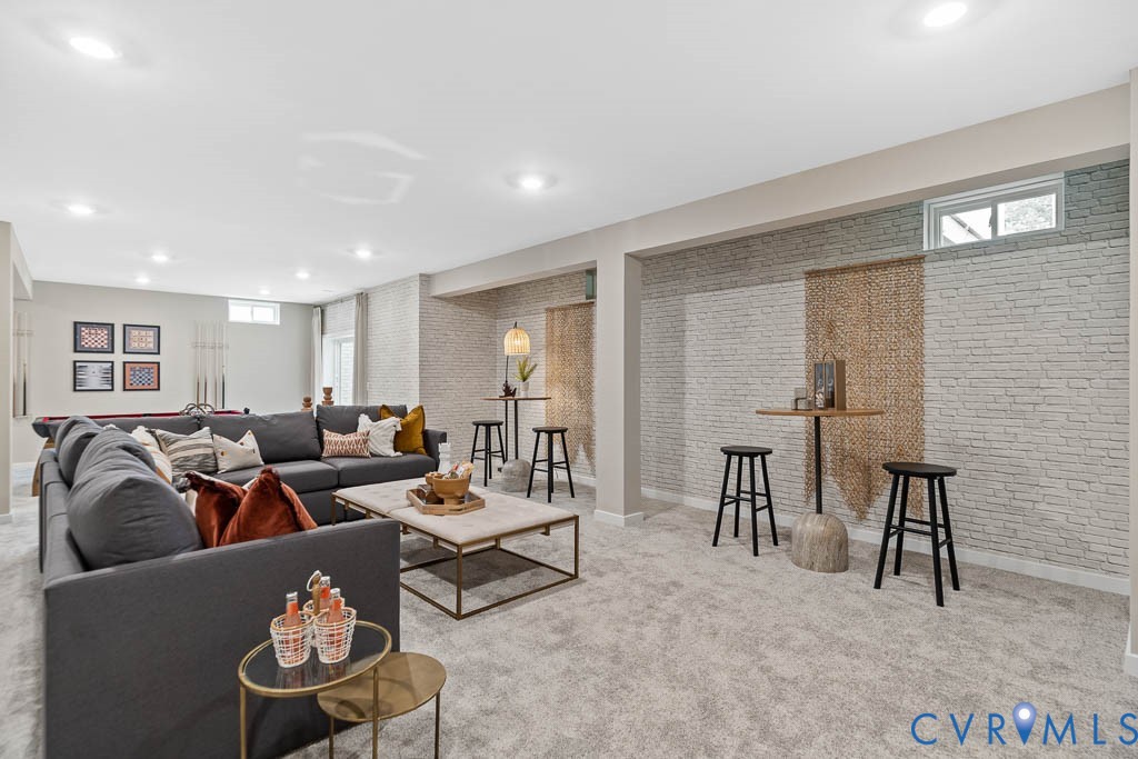Recessed lighting, light gray carpet, white brick-finish accent walls, and a visible window