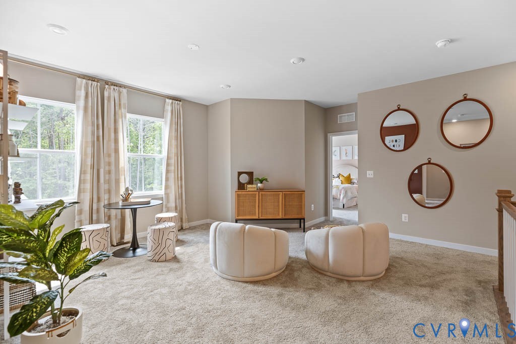 Carpeted landing area featuring multiple windows, recessed lighting, and a neutral color palette