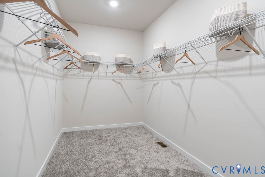 Recessed lighting illuminates a carpeted closet featuring built-in wire shelving