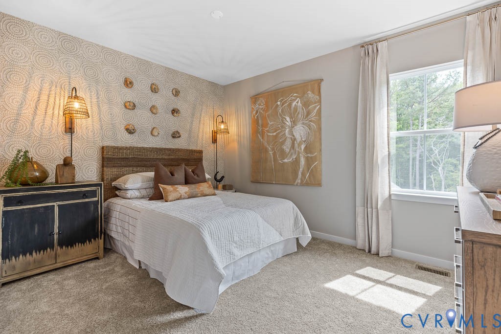 Plush carpeting, large window with natural light, textured accent wall, recessed lighting, and wall-mounted sconces