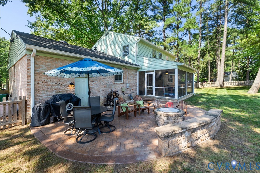 Brick paver patio with a stone fire pit and built-in seating