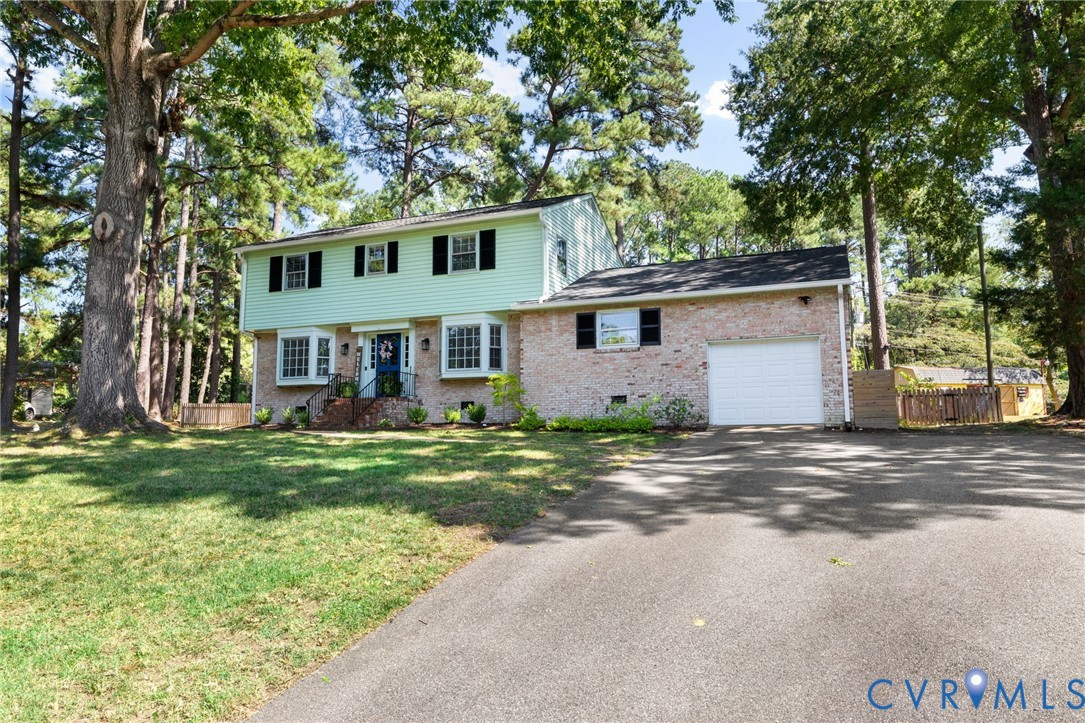 Brick and siding exterior with multiple bay windows, black window shutters, and a front entry door with sidelights