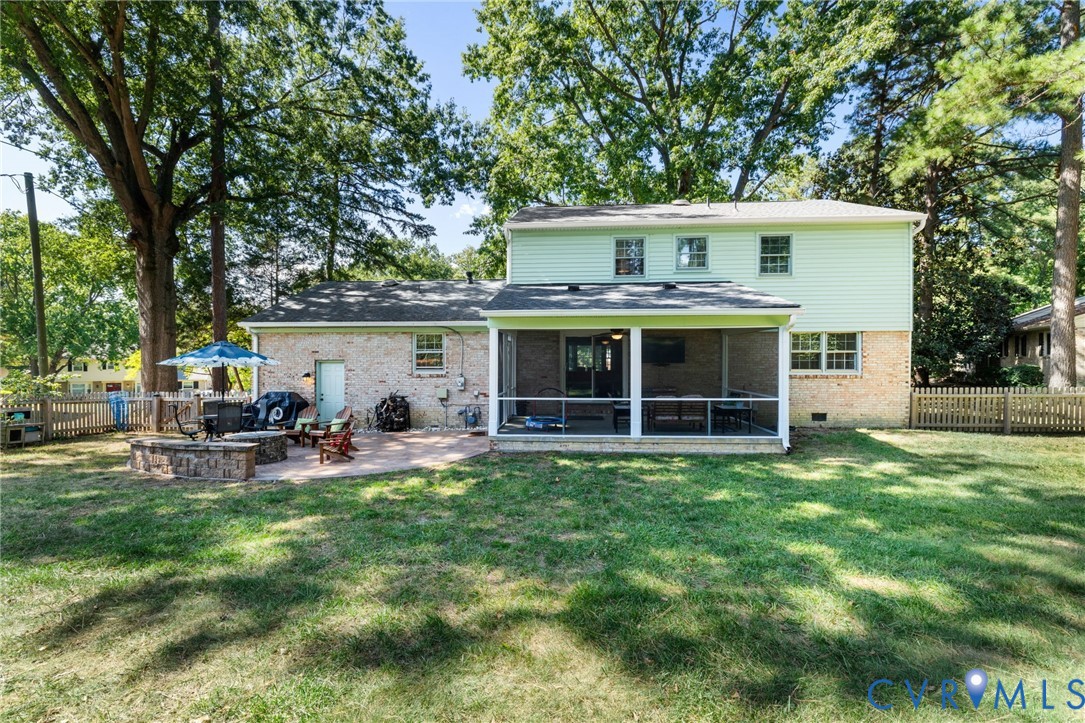 Screened porch, brick exterior, rear patio, and wood fencing
