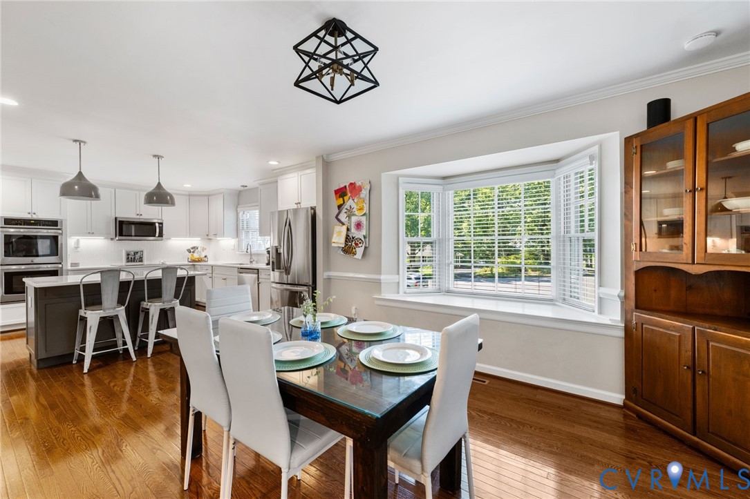 Hardwood flooring, bay window, kitchen island with seating, stainless steel appliances, and recessed lighting. Hardwood flooring, bay window, kitchen island with seating, stainless steel appliances, and recessed lighting.