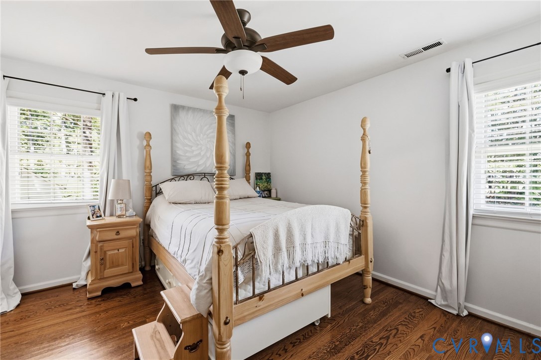 Hardwood flooring, painted white walls, white window blinds, and a ceiling fan with integrated lighting