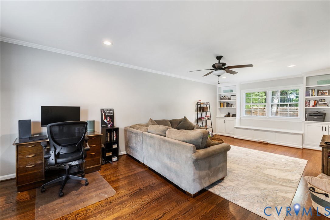 Hardwood-finish flooring, recessed lighting, crown molding, built-in shelving, and a ceiling fan with light fixture