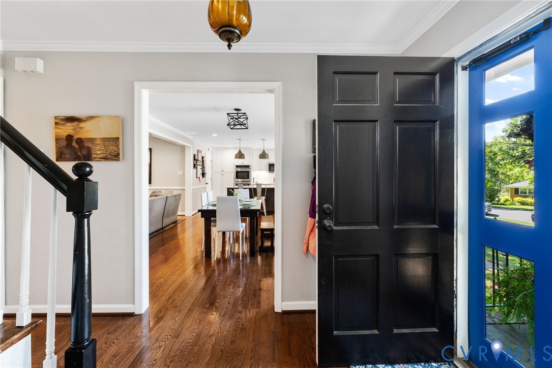 Hardwood flooring throughout, bright entry with a panel door, and a black baluster accent staircase Hardwood flooring throughout, bright entry with a panel door, and a black baluster accent staircase