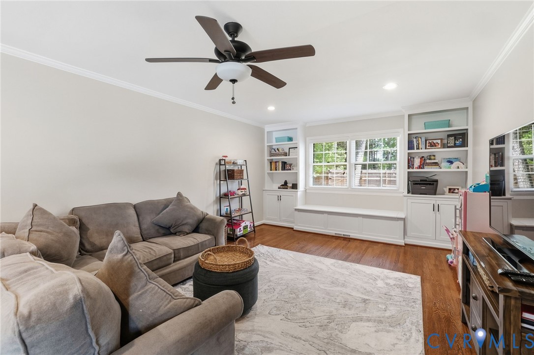 Built-in shelving, window bench seating, wood-finish flooring, and crown molding