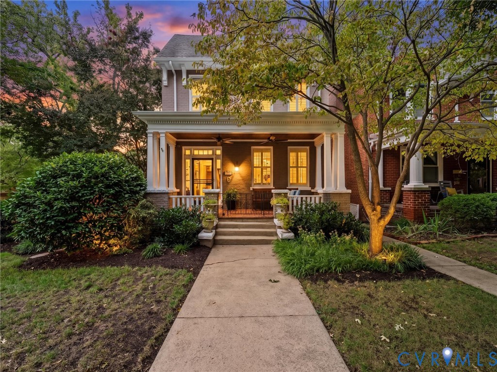 Charming front porch with mature landscaping & uplighting