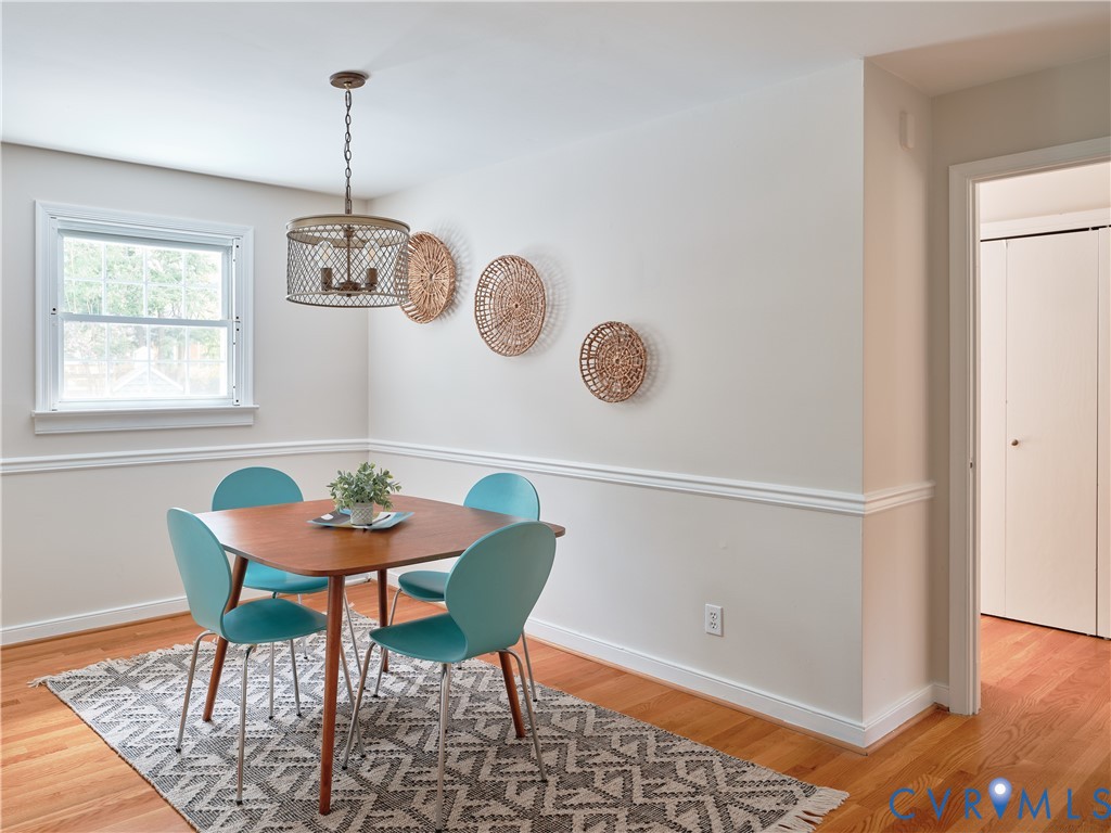 Hardwood flooring, crown molding, double-hung window, and a decorative ceiling light fixture