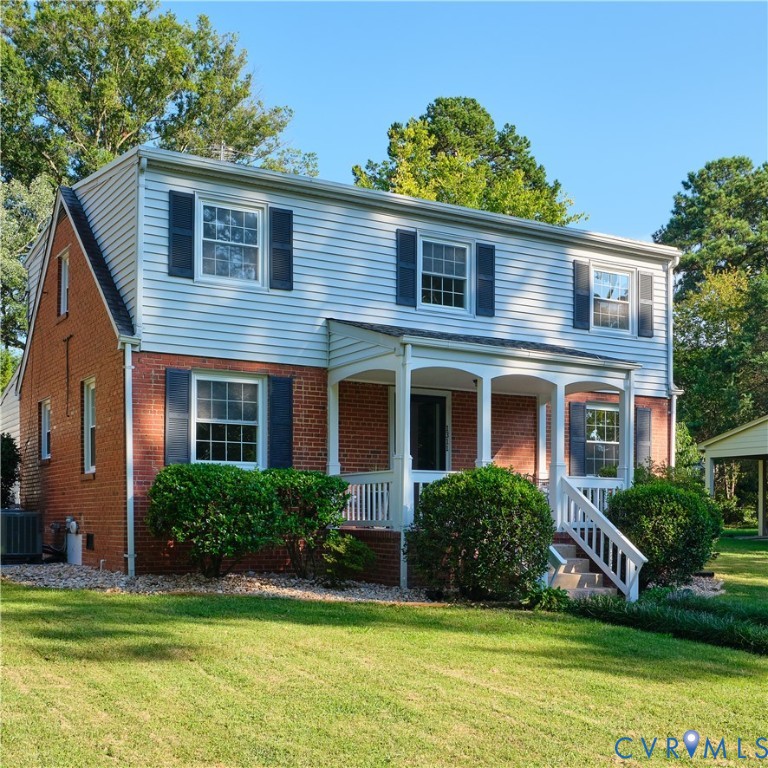 Brick and siding exterior with a covered porch, white railing, and decorative black shutters