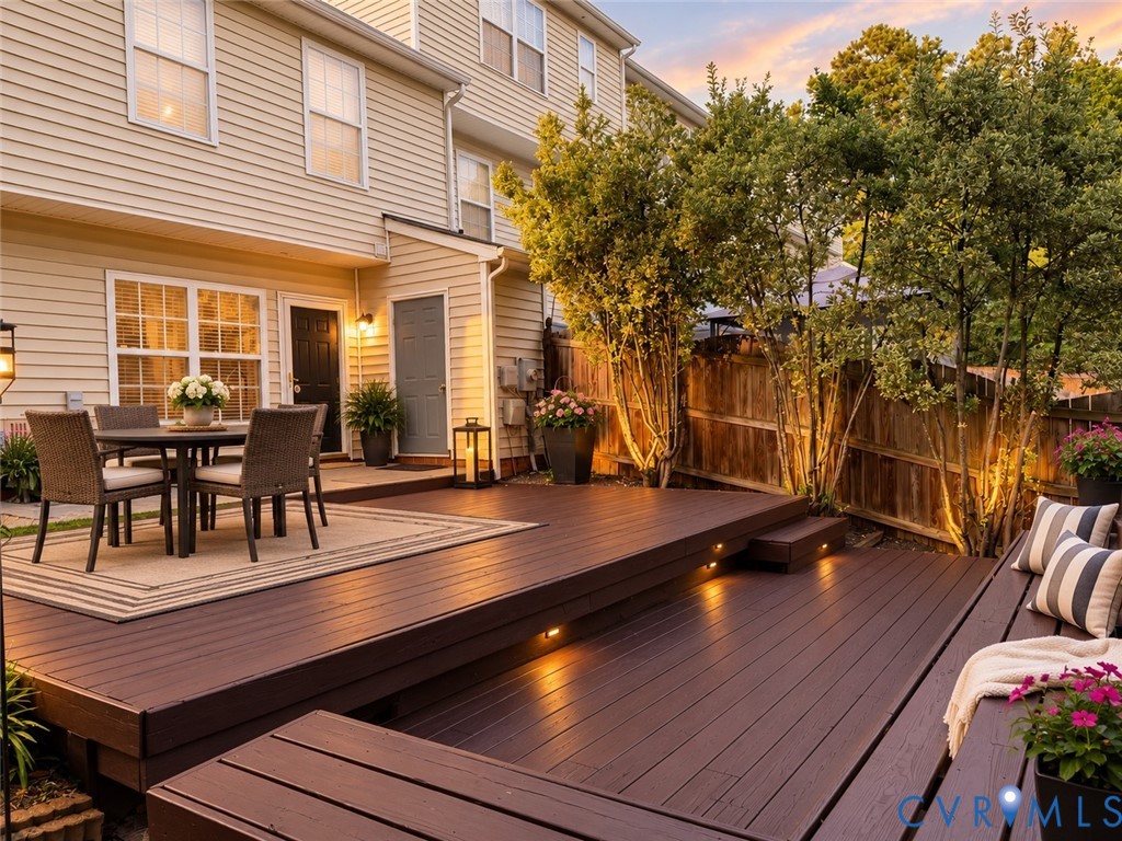 Multi-level rear deck with integrated bench seating, recessed step lighting, and a fenced perimeter