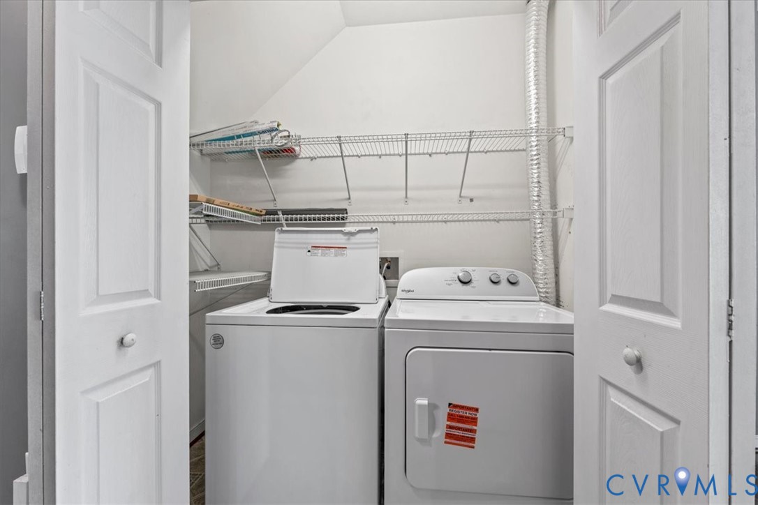Laundry closet featuring bi-fold doors, wire shelving, and appliances