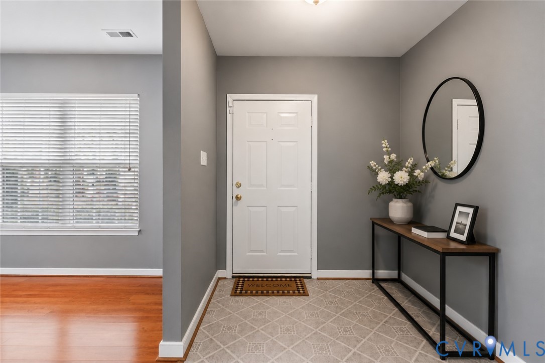 Entryway featuring a paneled door, patterned tile flooring, and a flush-mount light fixture