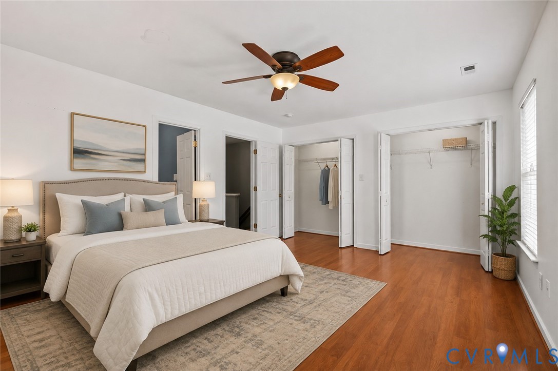 Hardwood-finish flooring, ceiling fan with integrated lighting, two bi-fold door closets with wire shelving, and two windows with blinds