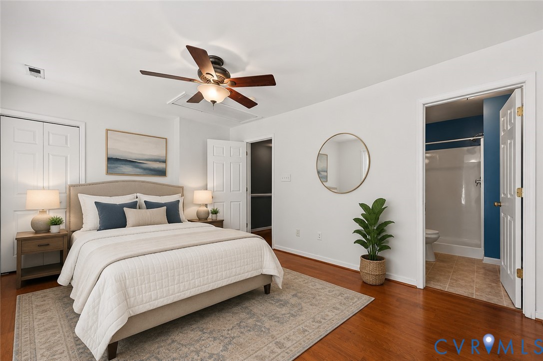 Wood-finish flooring, ceiling fan with integrated lighting, paneled doors, and a tiled bathroom with a shower