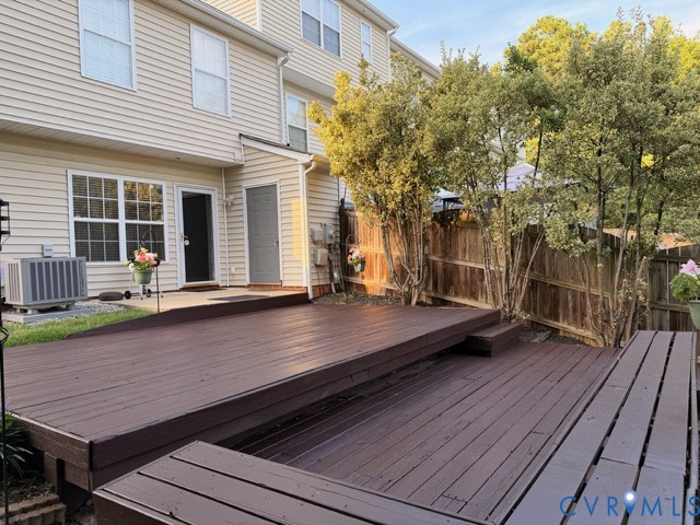 Multi-level wood deck with a privacy fence and mature trees