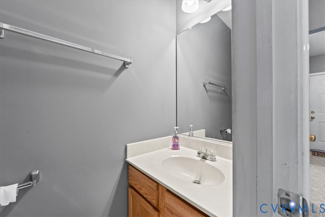 Integrated vanity with an oval sink, chrome faucet, and wood-finish cabinetry