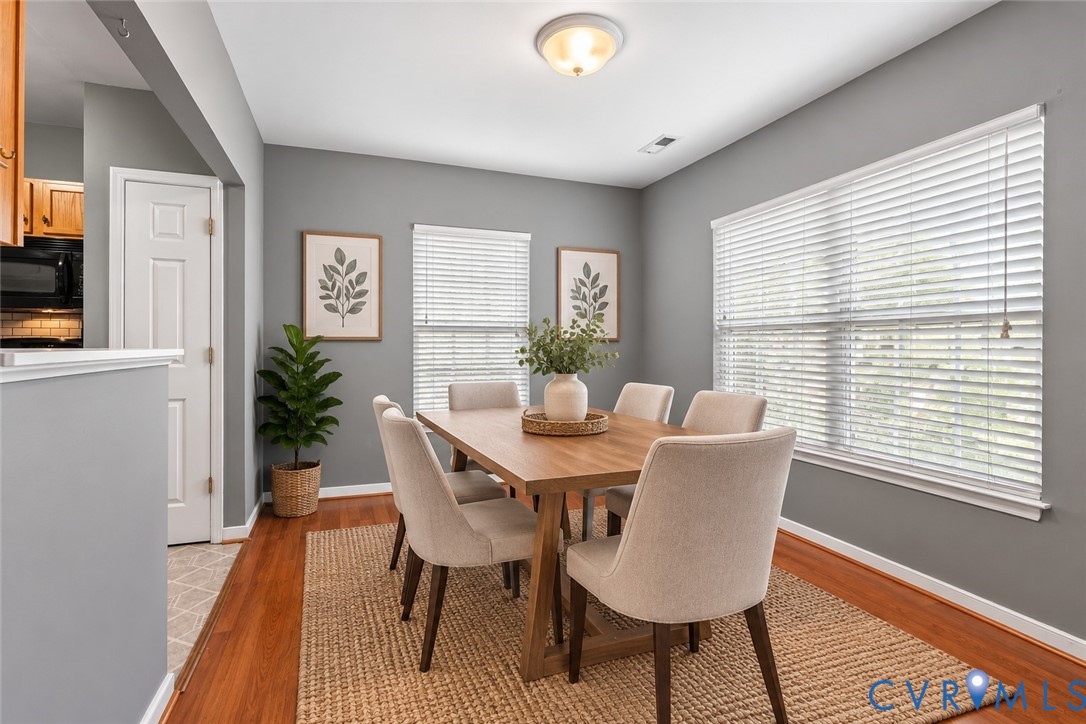 Recessed lighting, wood-finish flooring, white window blinds, and a built-in ceiling light fixture