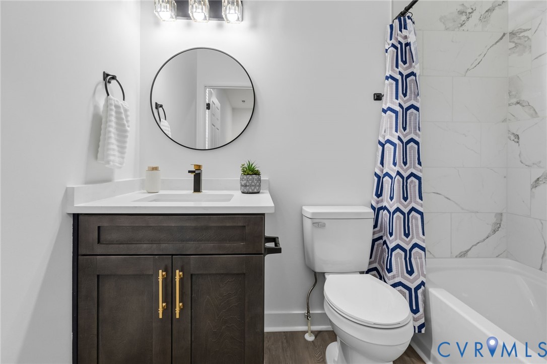 Vanity with dark wood-finish cabinetry, white countertop, and integrated sink