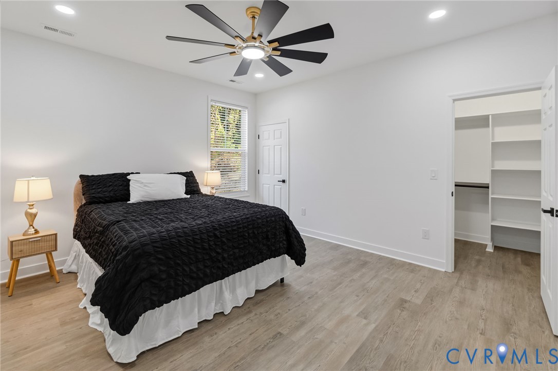 Recessed lighting, ceiling fan with integrated lighting, wood-finish flooring, white trim, and built-in closet shelving