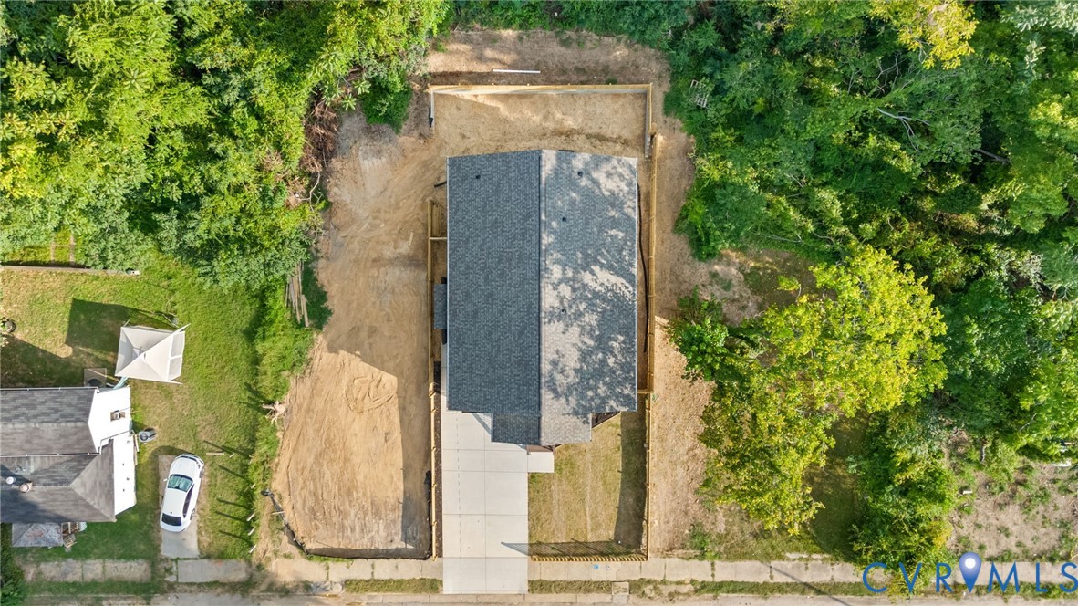 New construction residence featuring a gray shingle roof and a concrete driveway