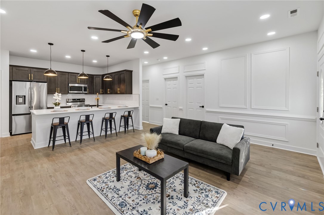 Contemporary kitchen featuring stainless steel appliances, dark wood-finish cabinetry, and a white countertop island
