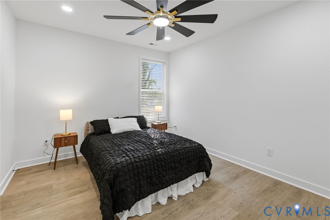 Recessed lighting, wood-finish flooring, and a ceiling fan with integrated lighting