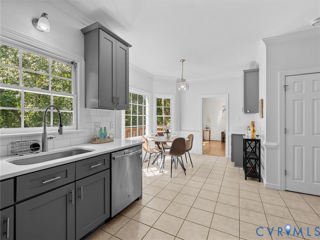 Kitchen featuring gray shaker-style cabinetry, stainless steel sink, subway tile backsplash, and light-toned tile flooring