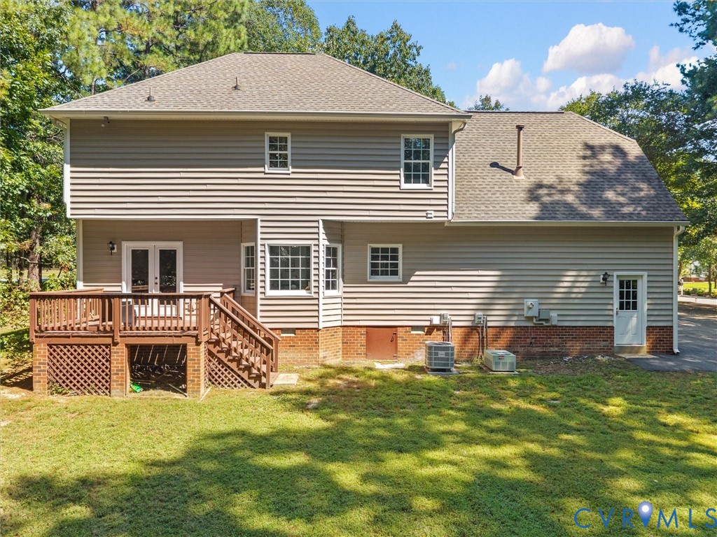 Exterior siding with multiple windows, a rear deck, and a second-story dormer