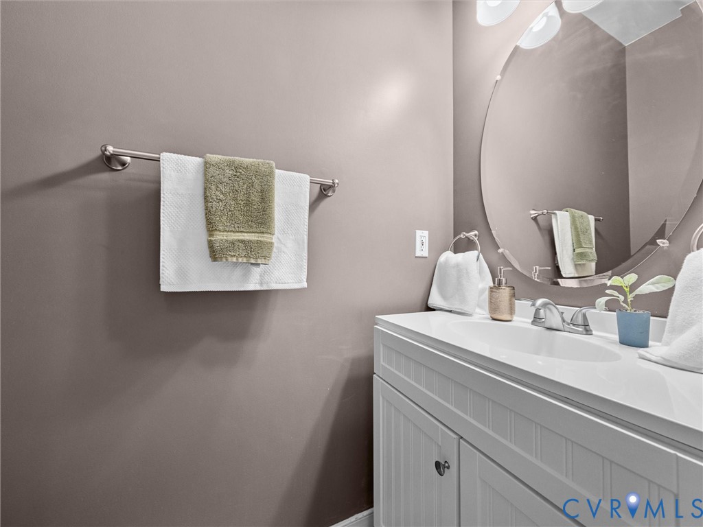 White vanity with beadboard paneling, integrated sink, and polished chrome faucet White vanity with beadboard paneling, integrated sink, and polished chrome faucet