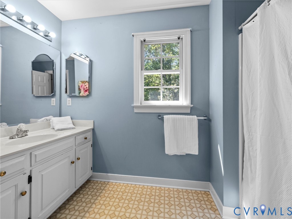 Vanity with integrated sink, chrome faucet, and white cabinetry