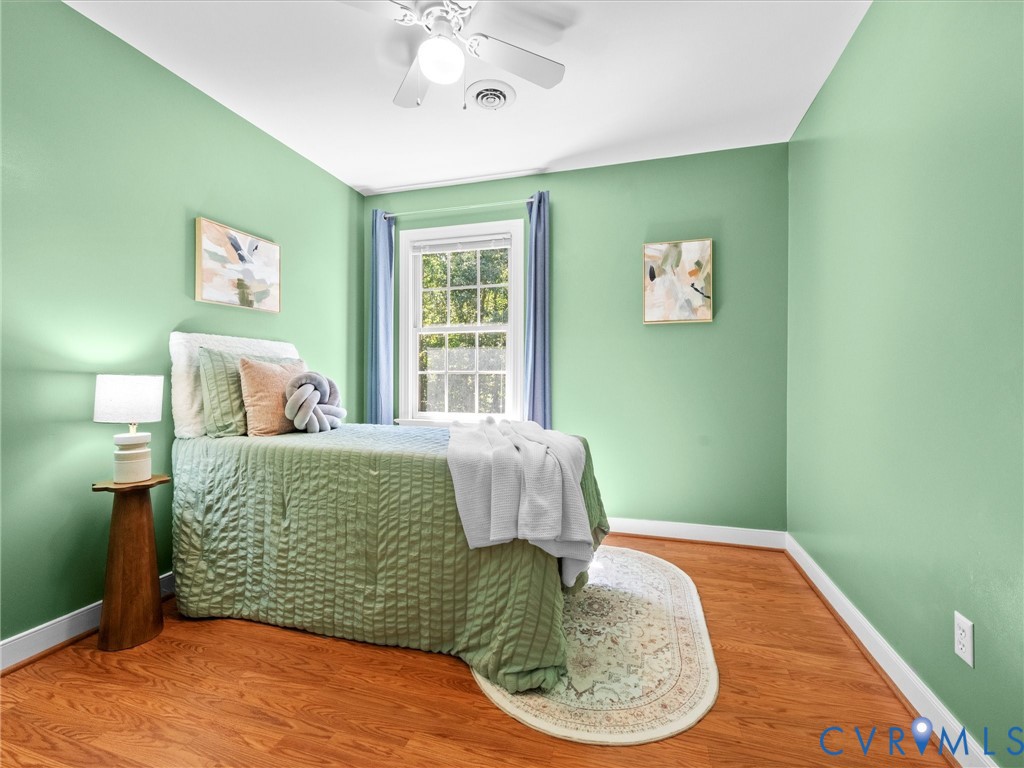 Bright room featuring wood-finish flooring, a ceiling fan, and a window with natural light