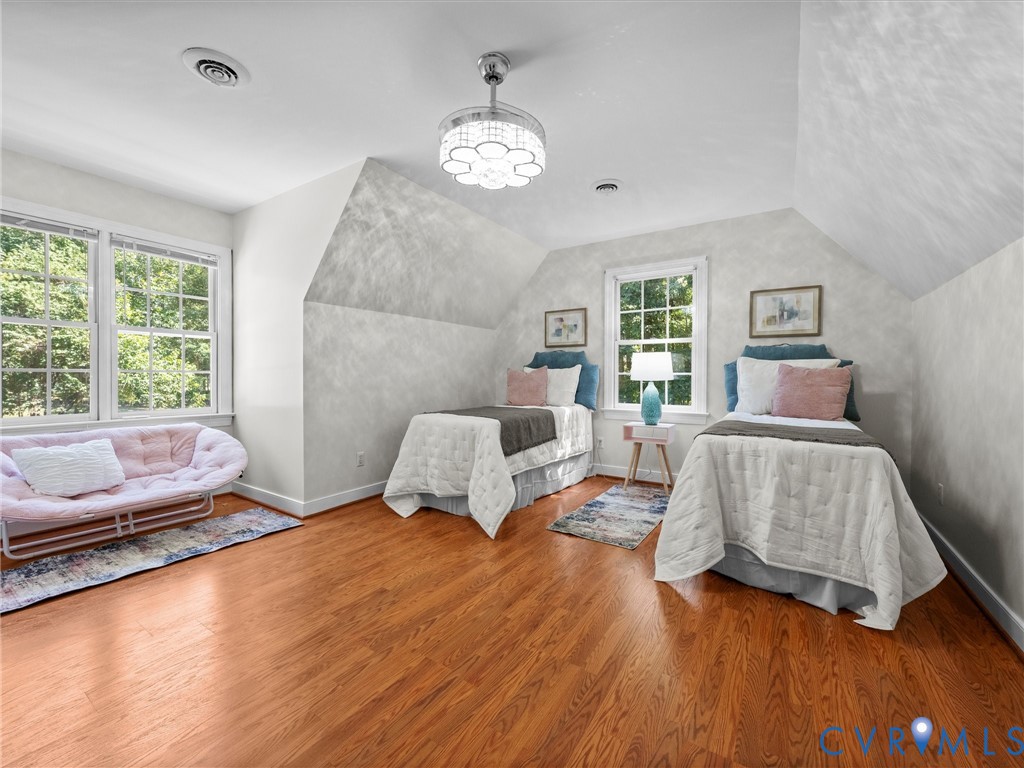 Hardwood flooring, painted walls, two large windows with muntins, and an overhead light fixture