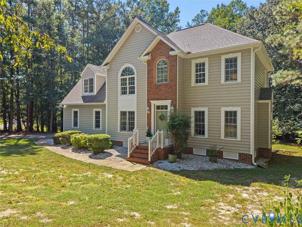 Traditional-style residence with light-colored siding and brick accents