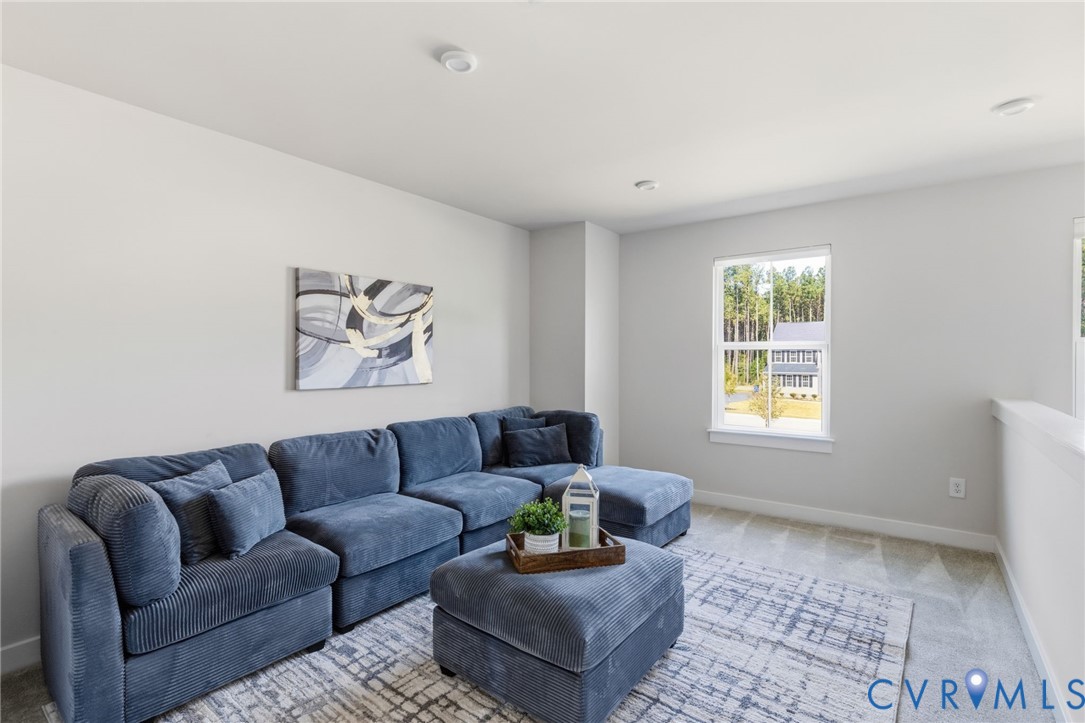 Carpeted room with a single window, recessed lighting, and a partial wall with a white railing