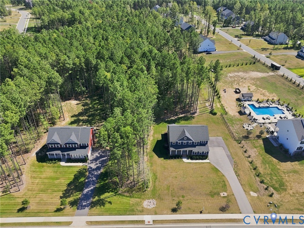 Two-story residences with dark roofs and light siding, surrounded by mature trees and landscaped green spaces