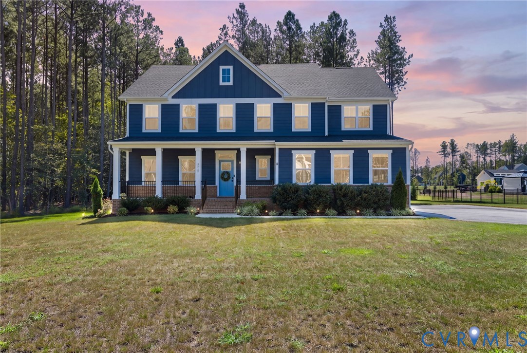 Two-story residence featuring a deep blue exterior, white-trimmed windows, a columned front porch, and a light blue front door