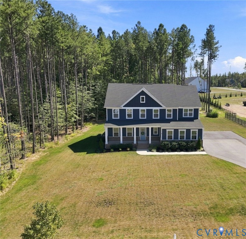 Traditional two-story residence featuring a deep blue exterior with white trim, a covered front porch, and a dark shingled roof