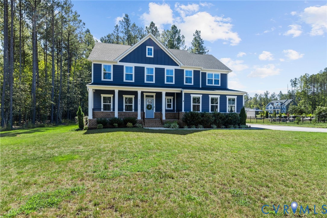 Two-story residence featuring a blue siding exterior, a covered front porch with white columns, a gray shingle roof, and white-framed windows