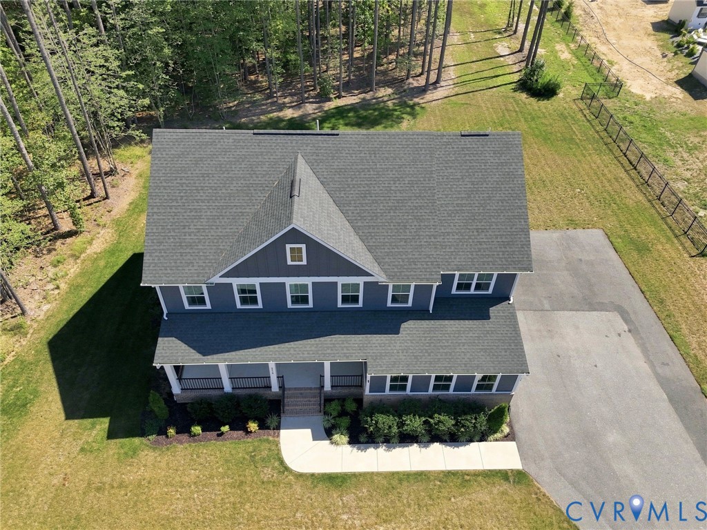 Two-story residence with a gray shingle roof, blue siding, a covered front porch, and a paved driveway