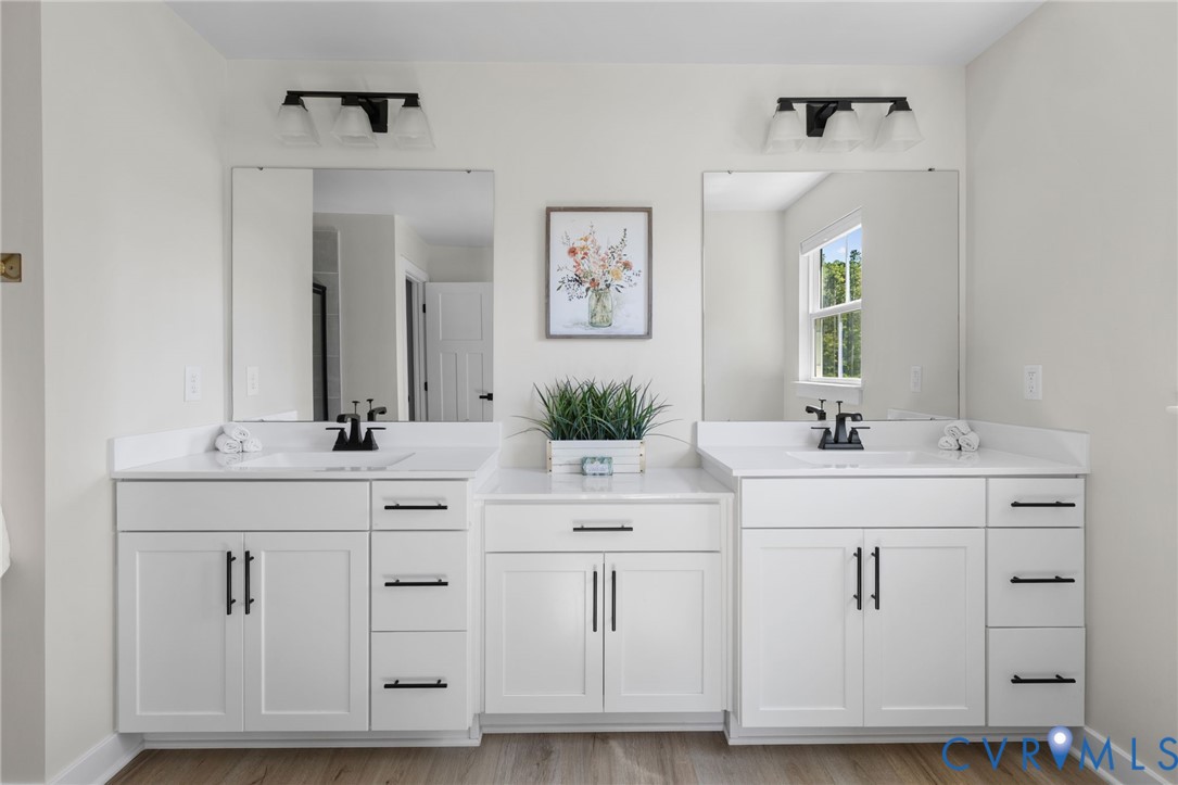 Dual vanities with white cabinetry and quartz countertops