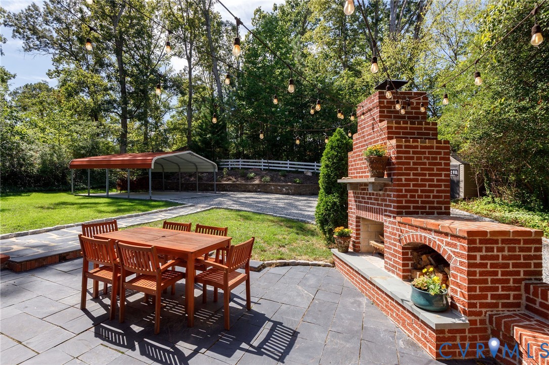 Outdoor fireplace, slate patio, and lawn by driveway