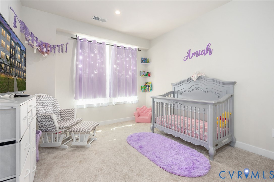 Recessed lighting, light-toned carpeting, multiple windows, and a built-in wall shelf