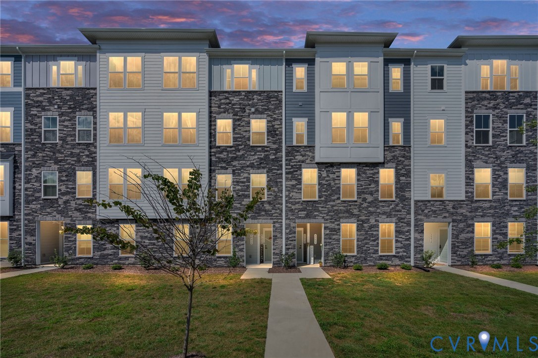 Three-story townhome with a mixed-material facade, featuring stone and siding