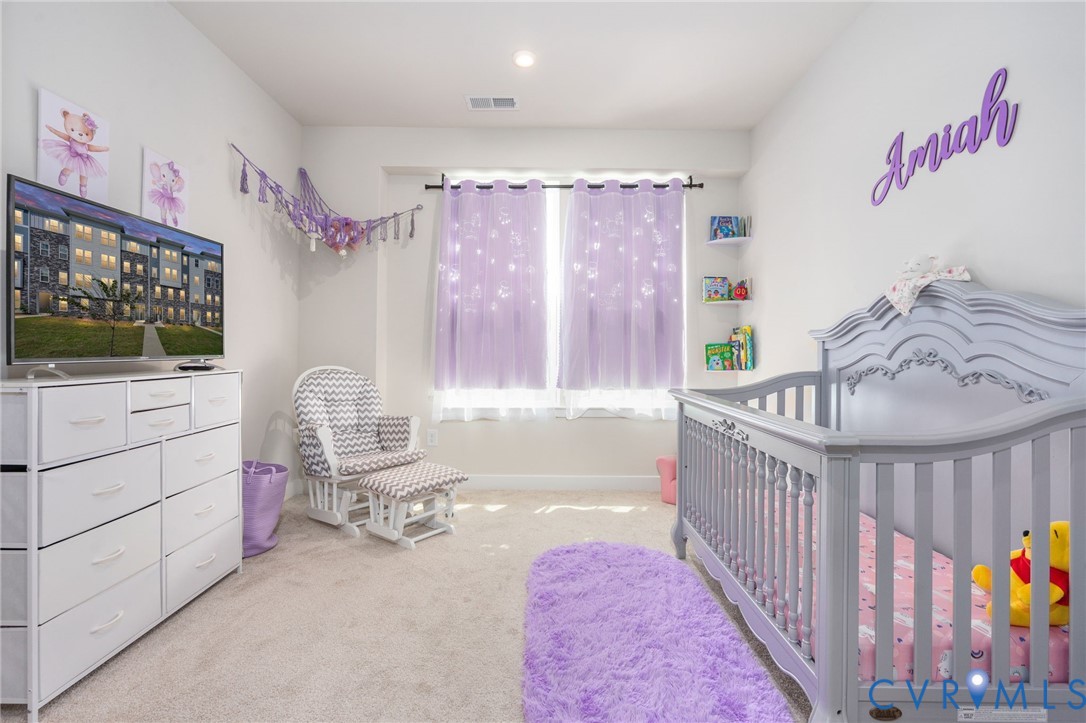 Recessed ceiling lighting, carpeted flooring, window with sheer curtains, wall-mounted shelving