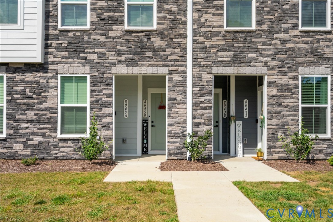 Stacked stone exterior with white window frames and multiple entryways