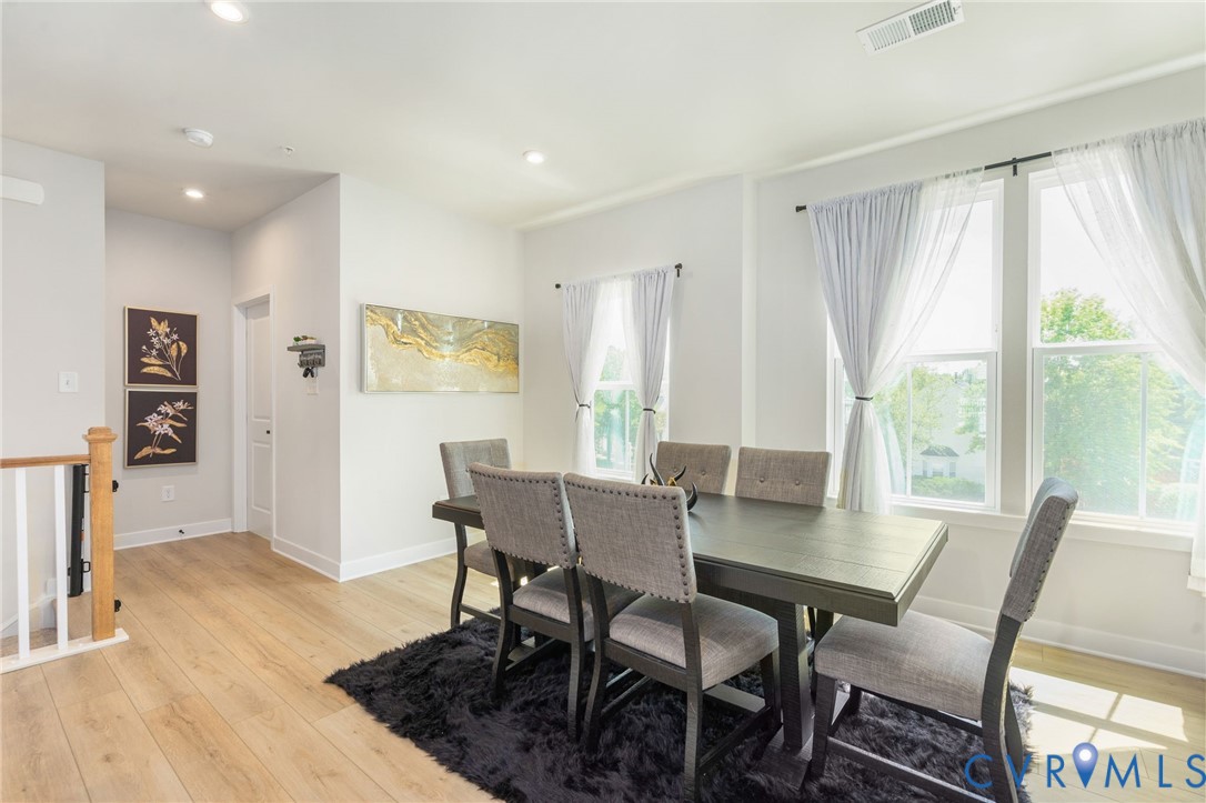 Recessed lighting, wood-finish flooring, white walls, white trim, and white window frames