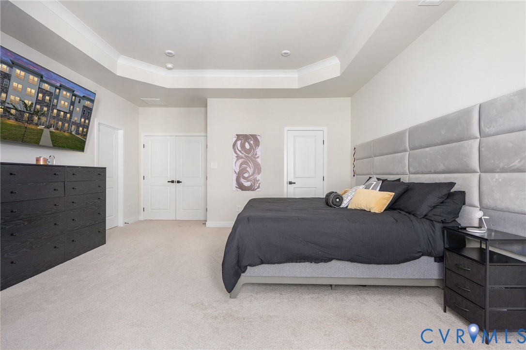 Recessed lighting, tray ceiling, carpet flooring, and white paneled doors