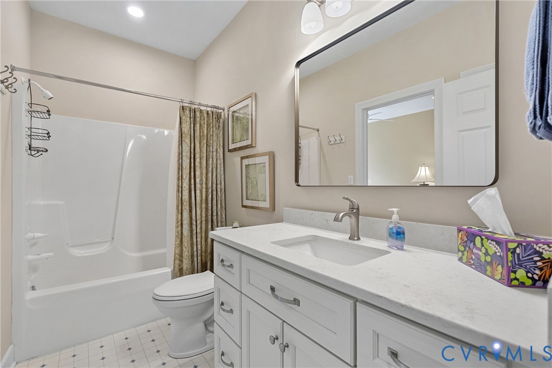 White vanity with brushed nickel hardware, integrated sink, and light-toned countertop